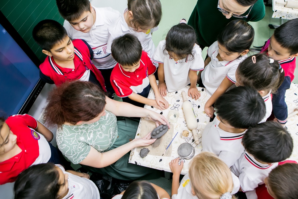 A teacher working with younger pupils